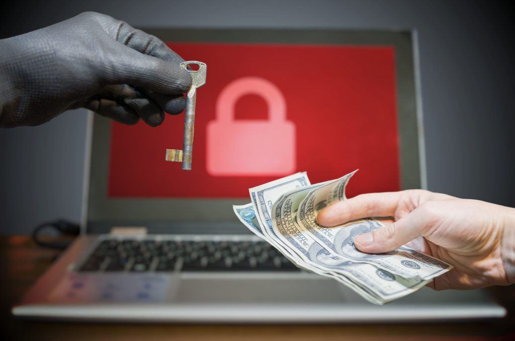 image of a robber giving a key and the victim giving money to get his data back
