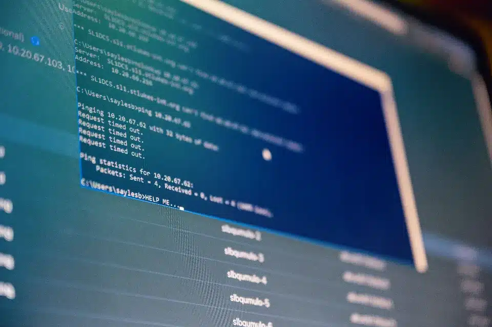 ecran-ordinateur-lignes-de-code-et-ping-en-erreur Capture d'écran d'un ordinateur affichant des lignes de code et un résultat de commande ping indiquant des échecs de connexion et des temps morts.