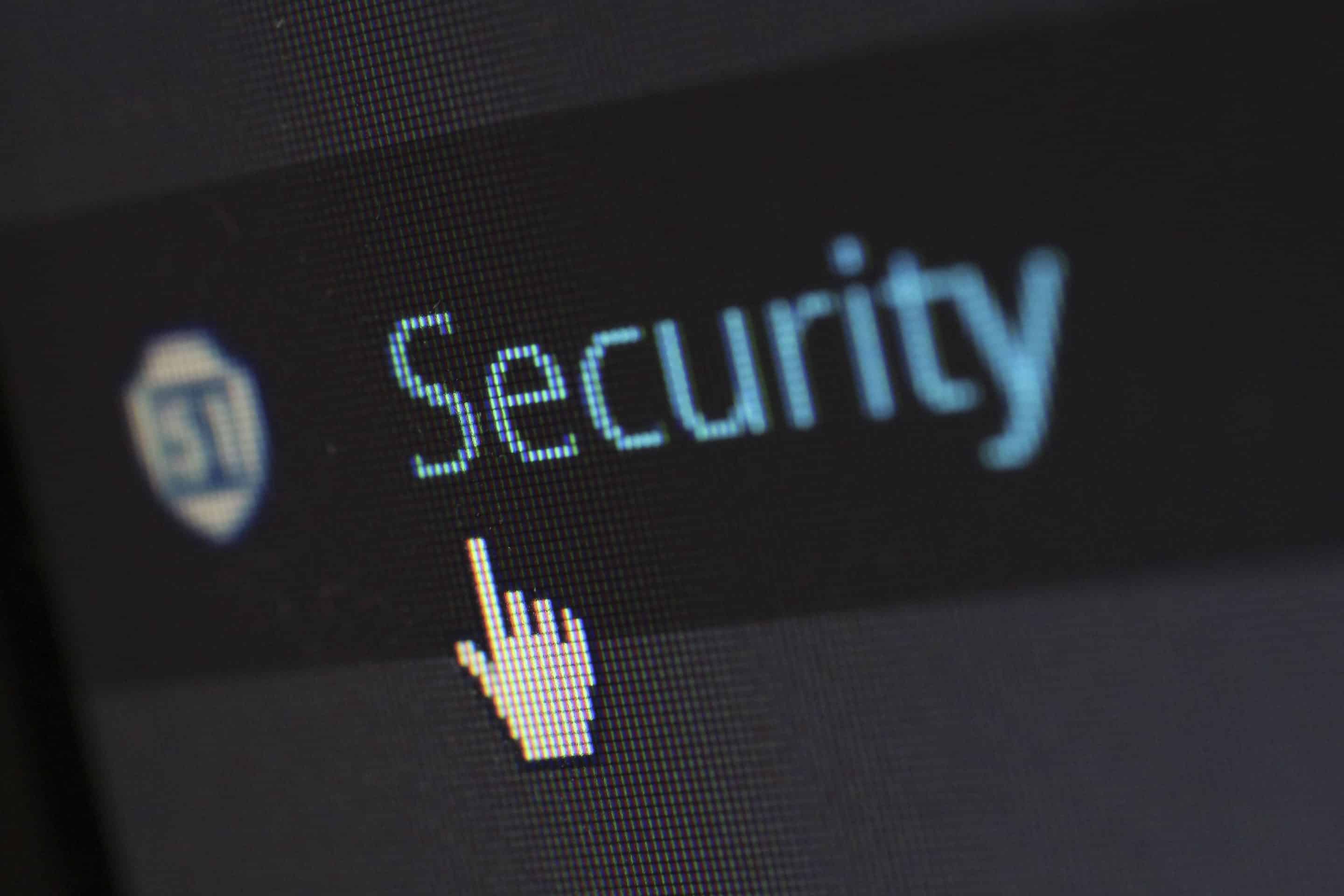 Le mot 'Security' en bleu sur un écran d'ordinateur, avec une icône de cadenas à gauche et un curseur de souris pointant vers le texte.